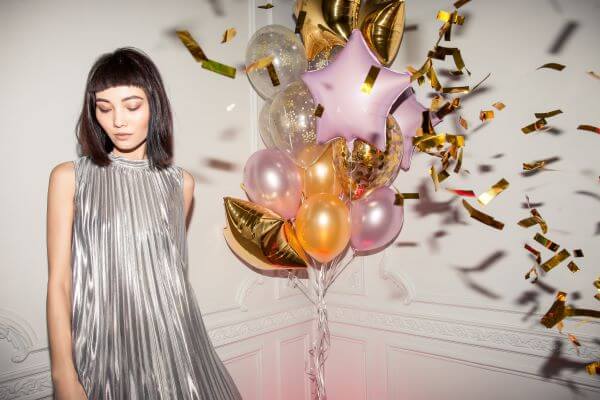 Teen celebrating 18th birthday with balloons